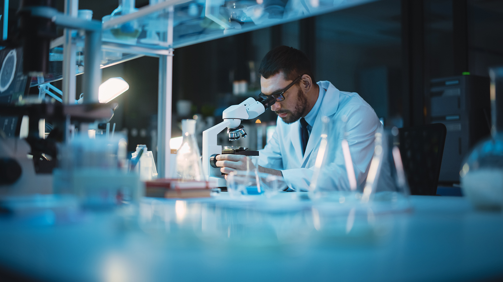 A scientist examining a sample for drug product contaminants